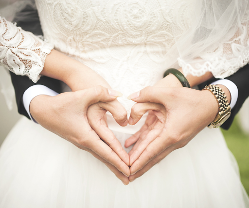 bride and groom creating heart with hands