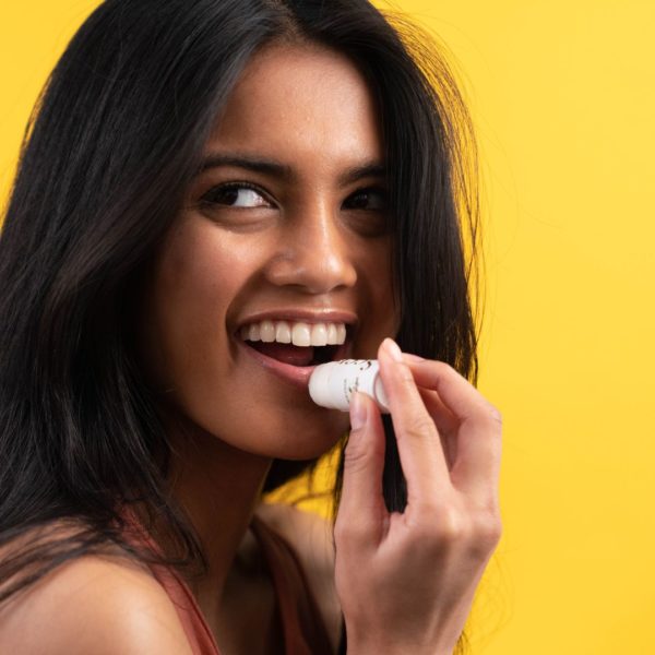 woman putting on lip balm