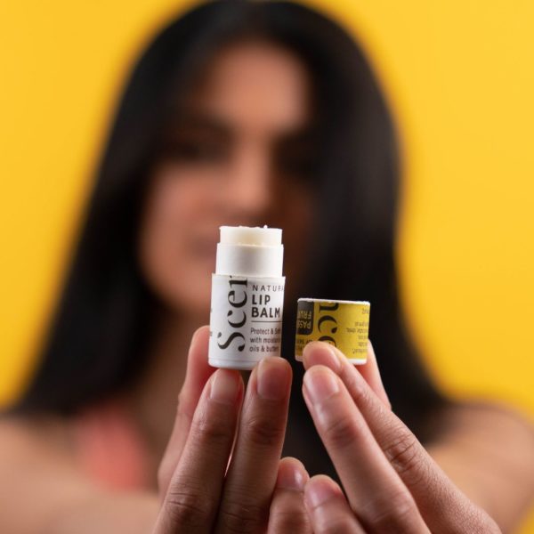 woman holding open passionfruit lip balm