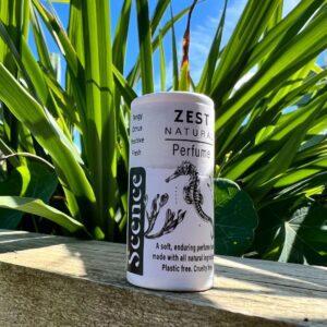 Natural perfume balm in front of plant, zest
