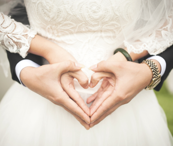 bride and groom creating heart with hands